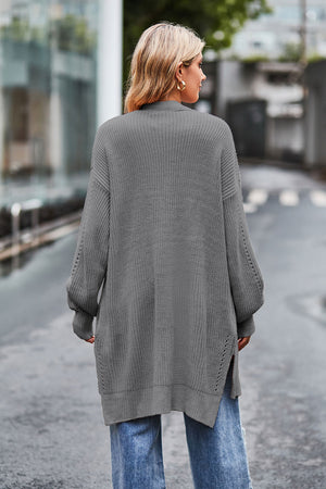 Open-knit longline cardigan in grey acrylic with side slits and balloon sleeves.
