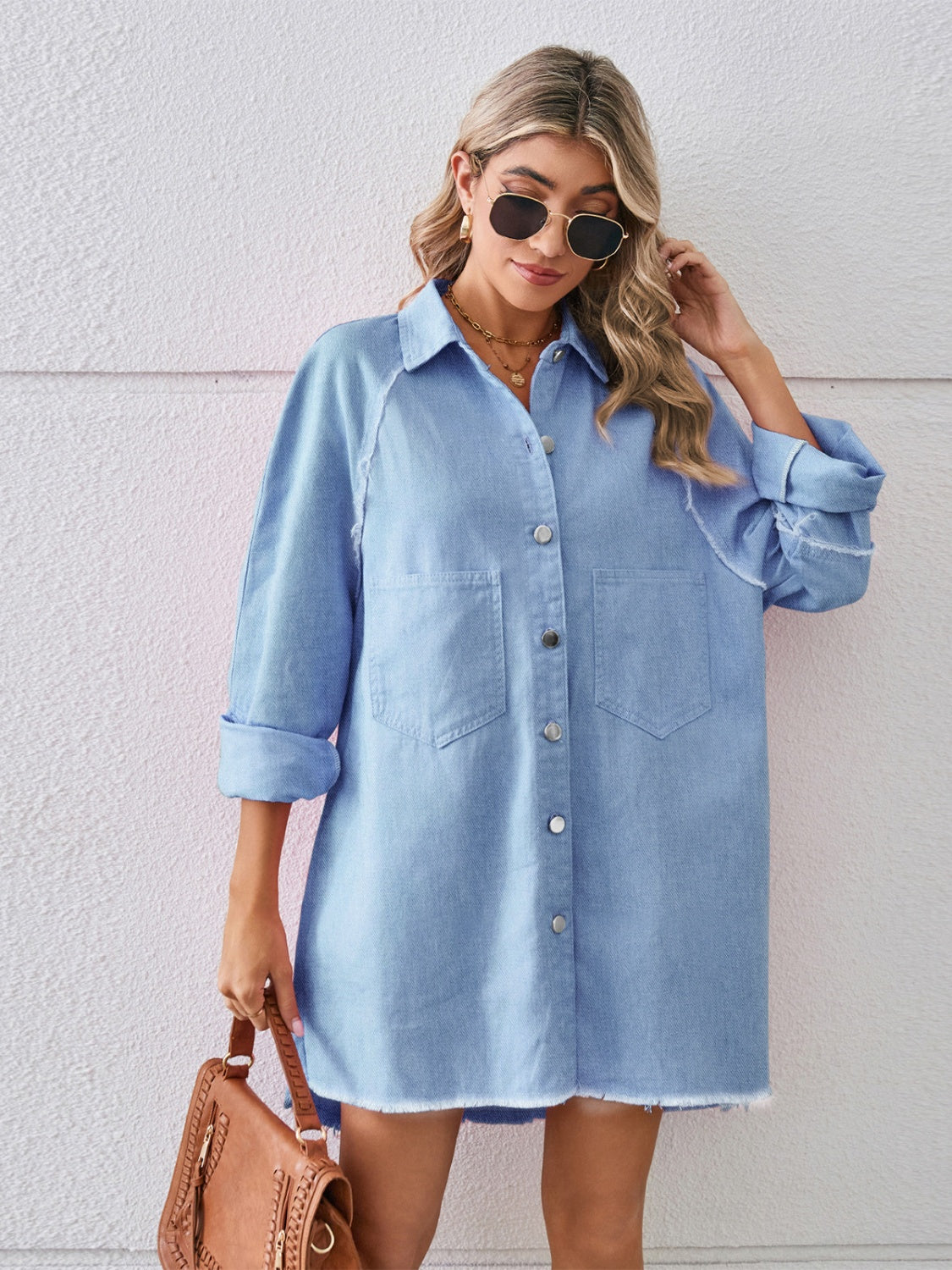 Light blue denim shirt dress with raw hem, button front, and two chest pockets.