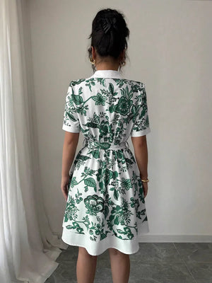 Floral print mini dress with tie belt in dark green and white, short sleeves, collared neckline.