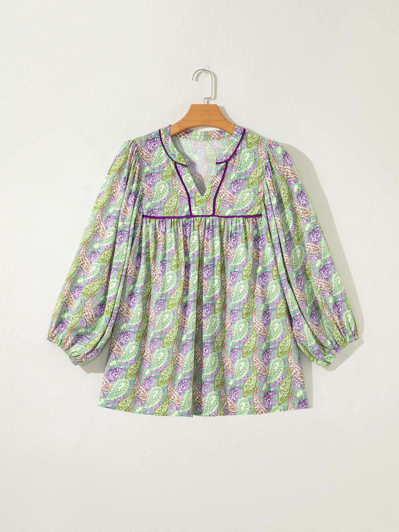 Paisley print blouse with puff sleeves and purple trim.
