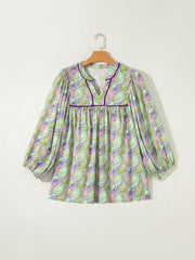 Paisley print blouse with puff sleeves and purple trim.