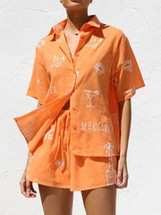 Orange button-up resort shirt and shorts set with white margarita and chili pepper print.