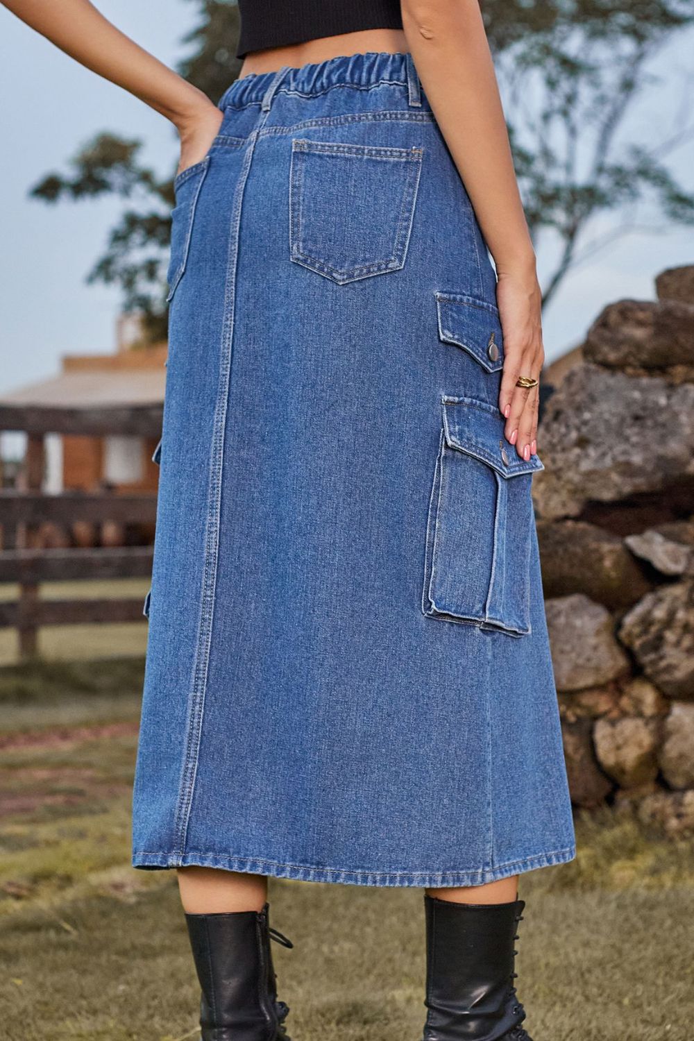 Denim midi skirt in medium blue with cargo pockets, buttoned flap pockets, and a slit.