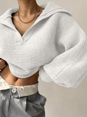 White knit sweater with wide collar and balloon sleeves, featuring a textured ribbed pattern.