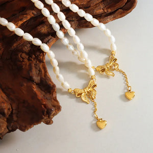 Gold pearl necklace with bow and heart drop charms