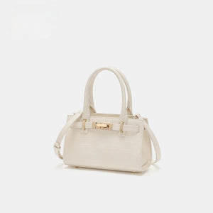 Off-white crocodile-embossed mini tote handbag with gold hardware and top handles.