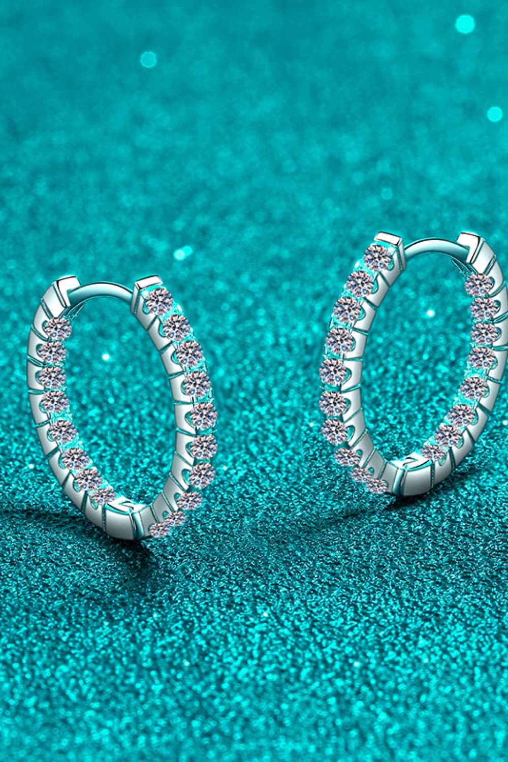 Silver pavé crystal huggie hoop earrings with detailed metalwork.