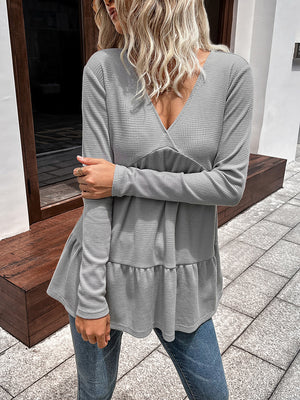 Light gray waffle knit peplum top with V-neck and tiered ruffle hem.