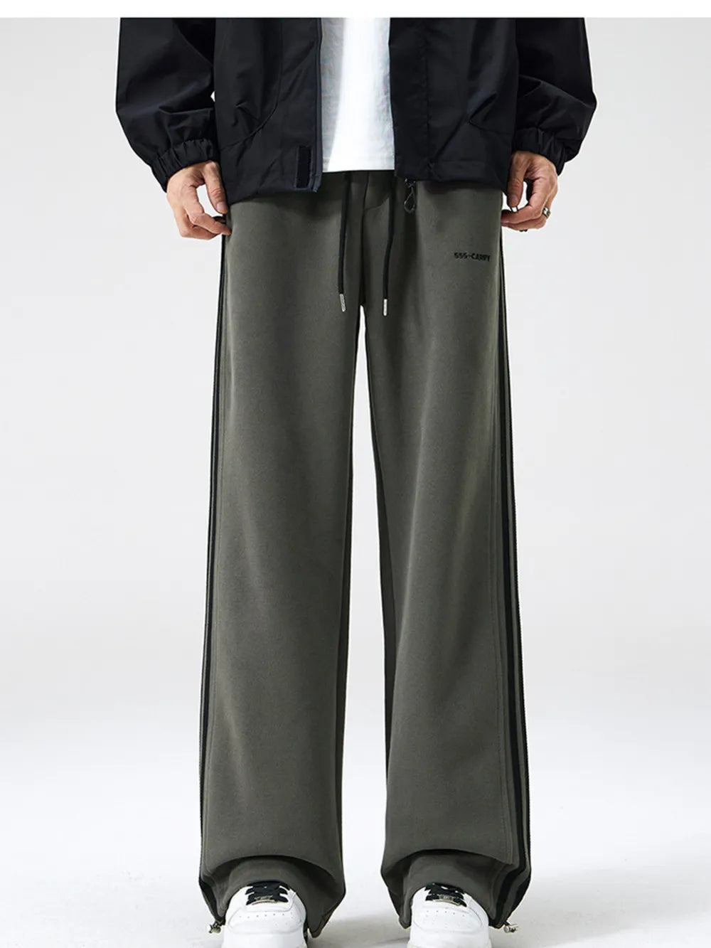 Gray green sweatpants with black side stripes and drawstring waist.