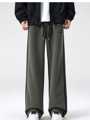 Gray green sweatpants with black side stripes and drawstring waist.