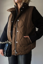 Quilted stand-collar utility gilet in taupe with snap and zip front closure.