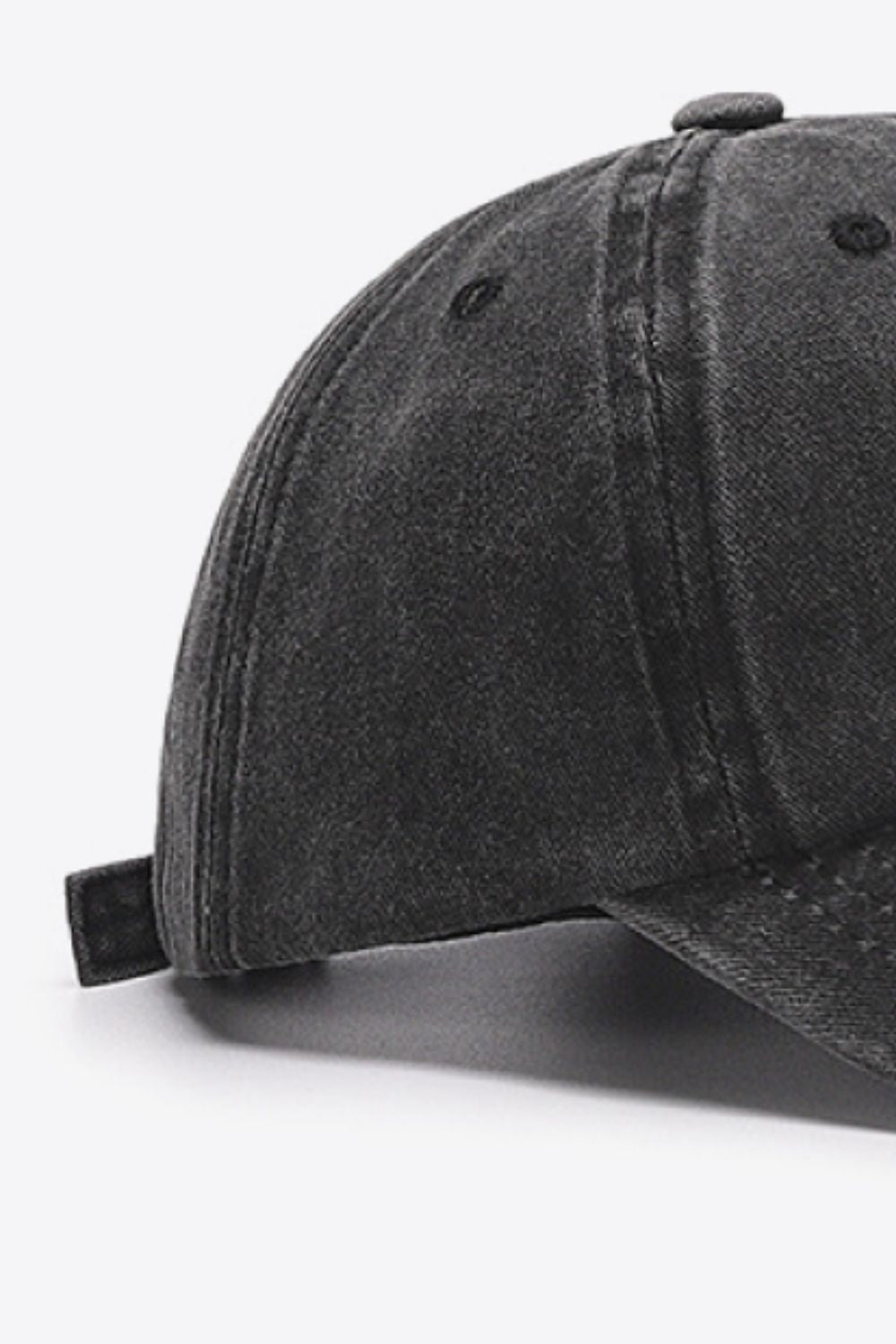 Washed cotton baseball cap in black with adjustable strap detail.