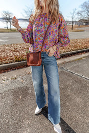 Purple floral print blouse with gathered sleeves and a mock neckline.