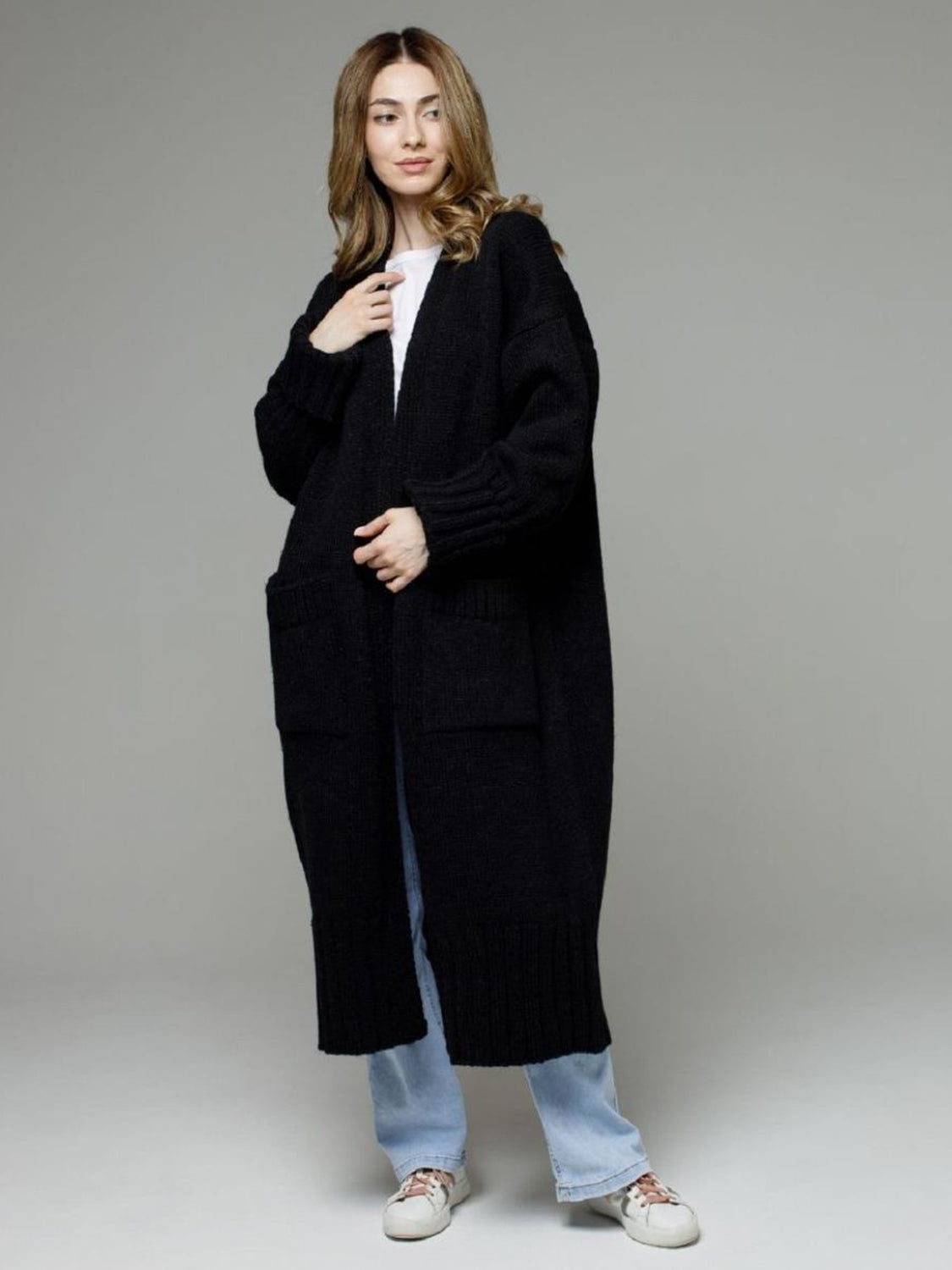 Black oversized ribbed-trim maxi cardigan with pockets, styled with a white tee and jeans.