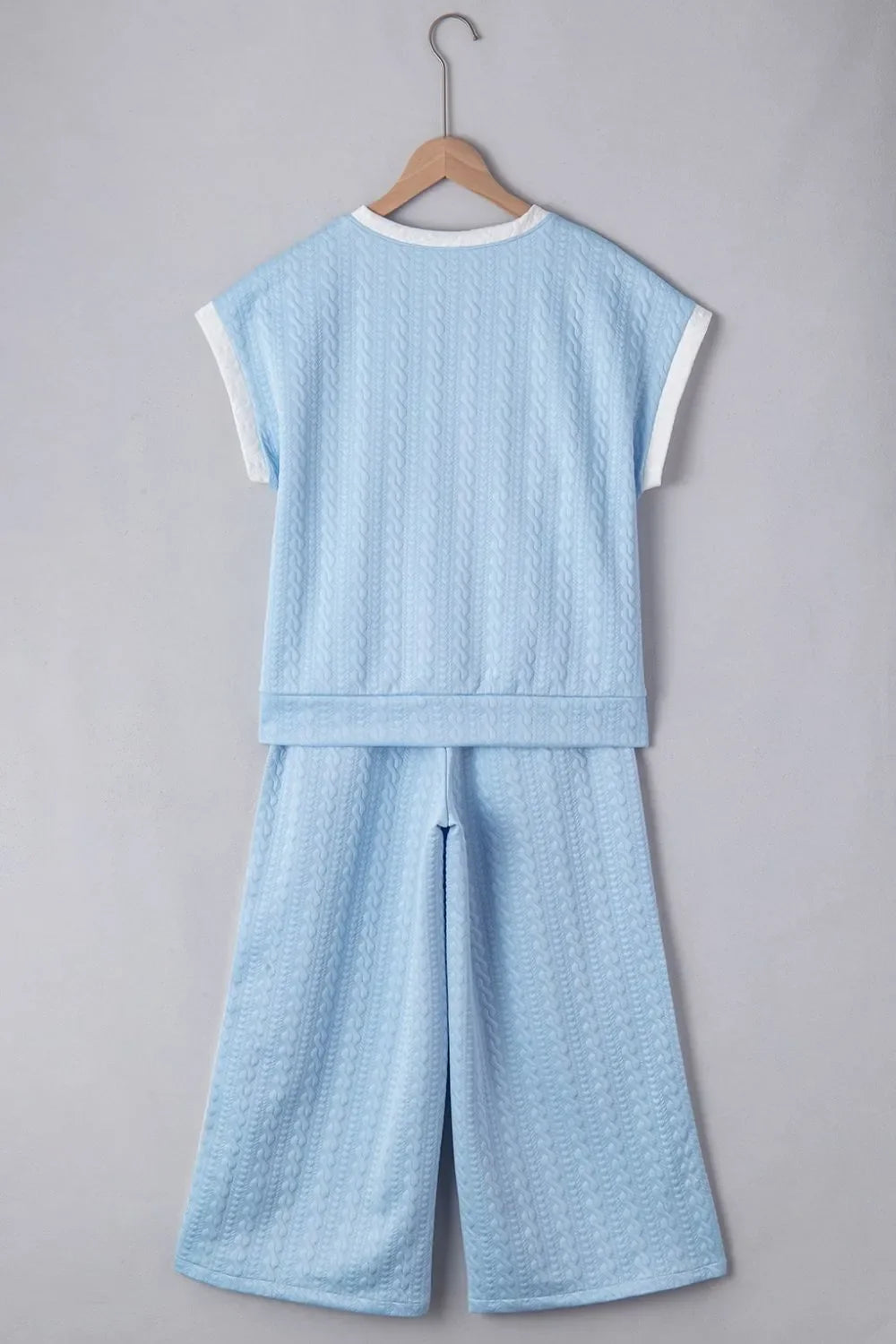 Light blue cable knit loungewear set with contrast trim on top and wide leg pants.