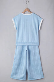 Light blue cable knit loungewear set with contrast trim on top and wide leg pants.