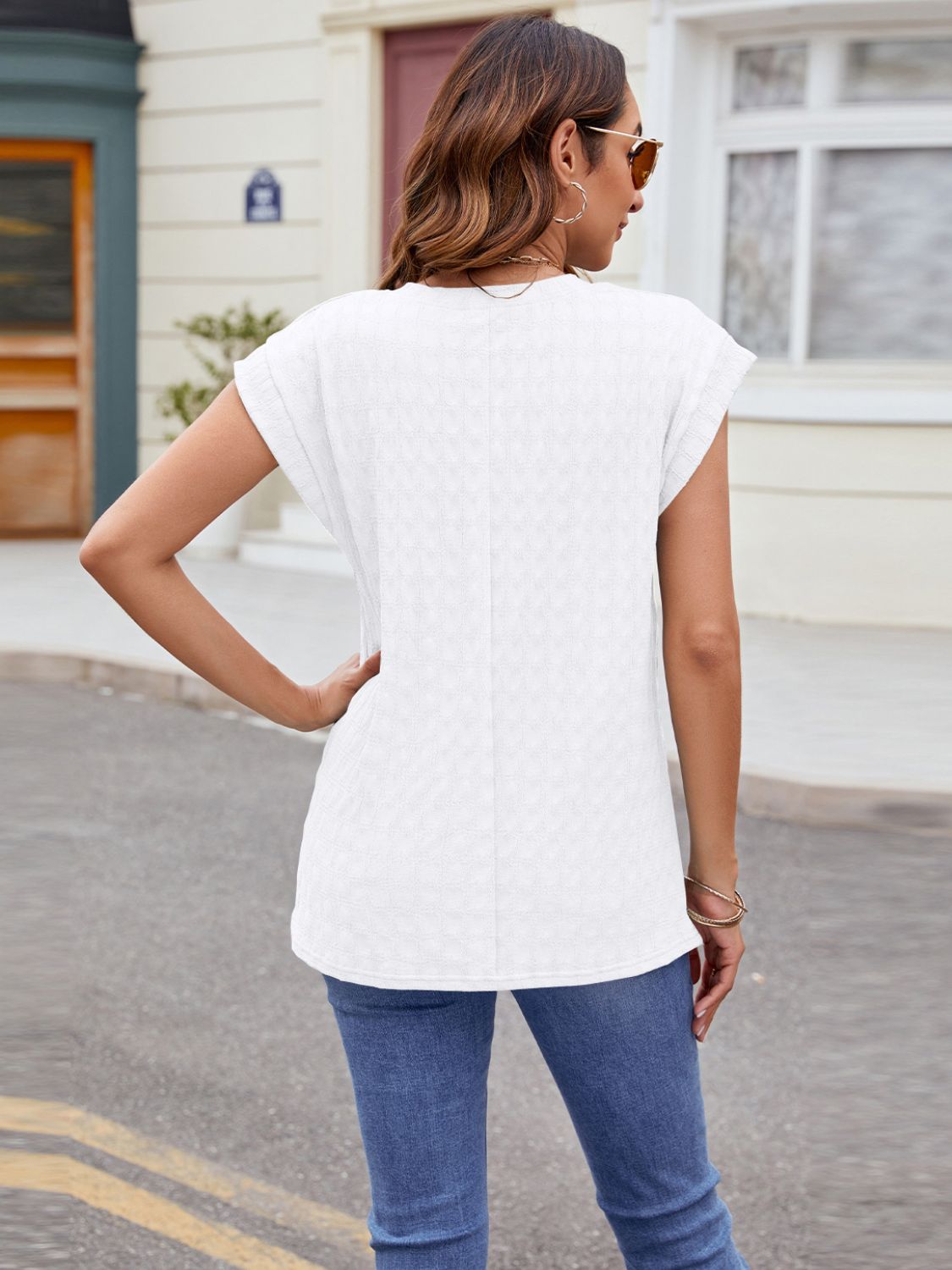 White cap-sleeve tee with subtle knit texture and relaxed fit.