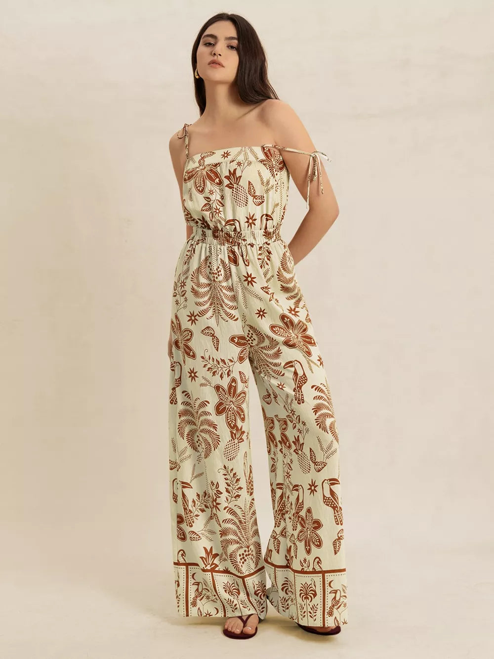 Tropical tie strap wide-leg romper in light green with brown floral and bird print.