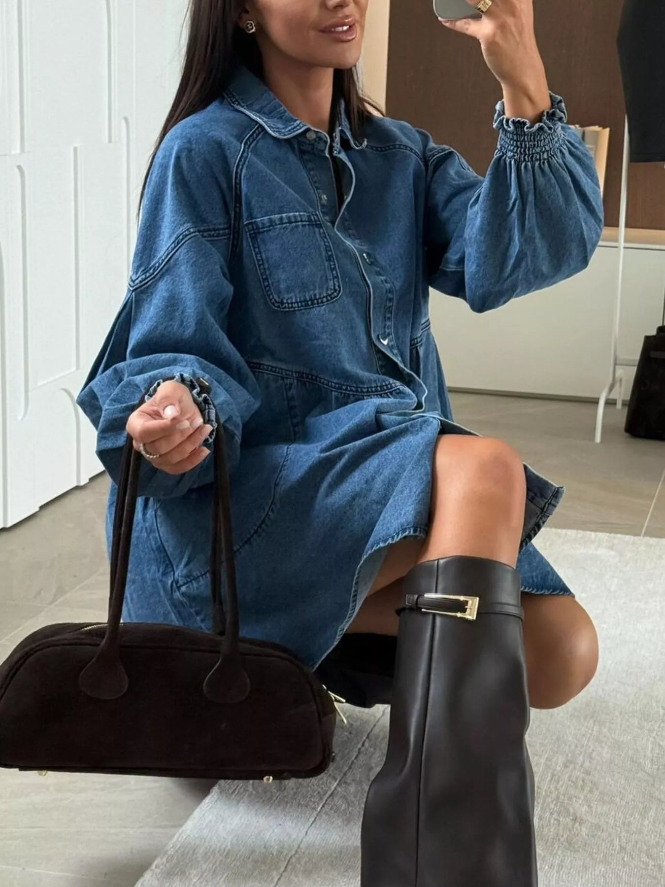 Blue denim mini dress with button front, chest pockets, and smocked sleeves.