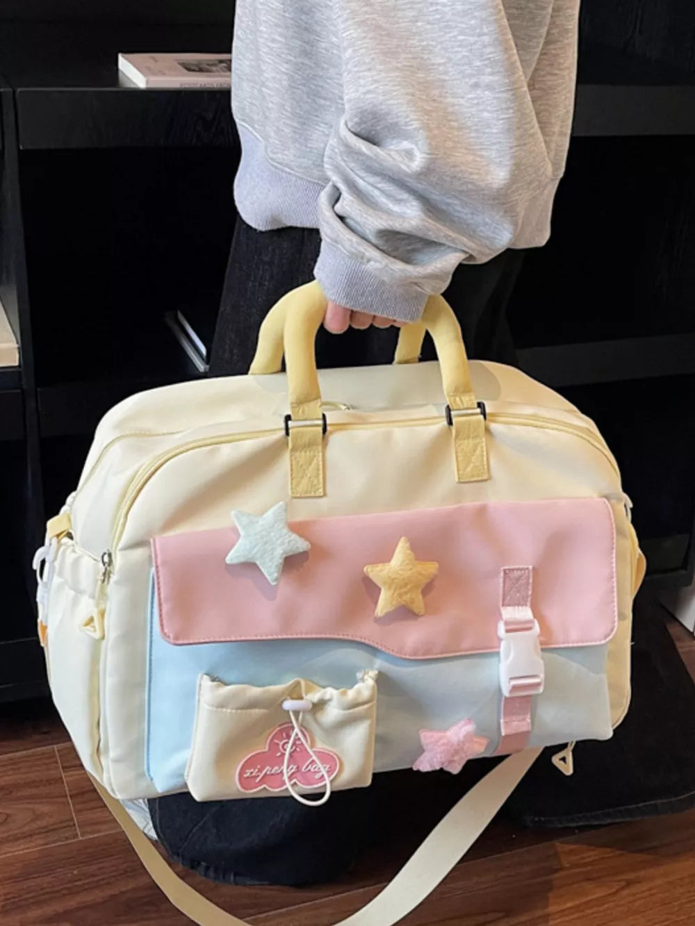 Chic color block travel bag with star embellishments and yellow handles.