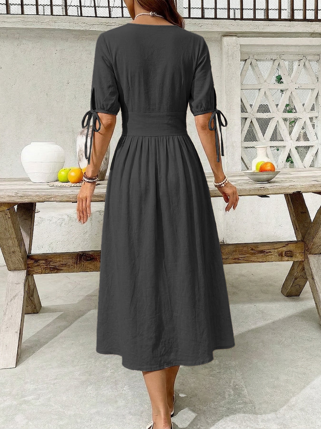 Black button-down midi dress with tie sleeve details and an a-line skirt.