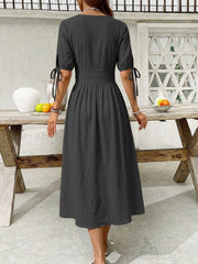Black button-down midi dress with tie sleeve details and an a-line skirt.