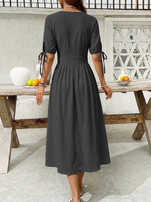 Black button-down midi dress with tie sleeve details and an a-line skirt.
