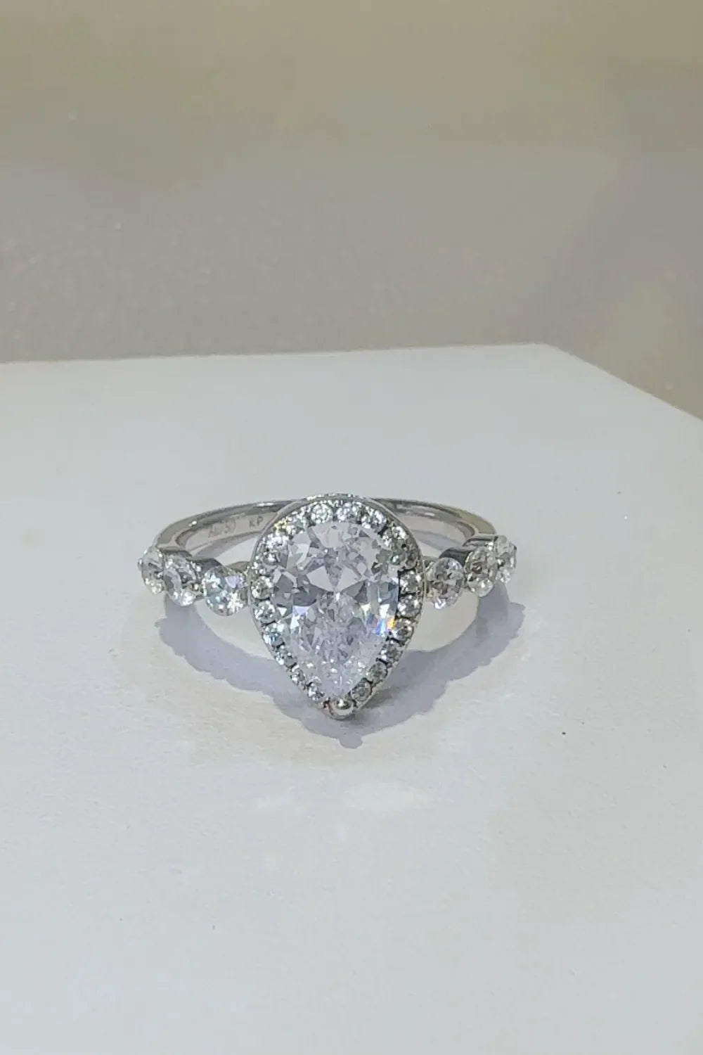 Silver pear-cut halo moissanite ring with accent stones