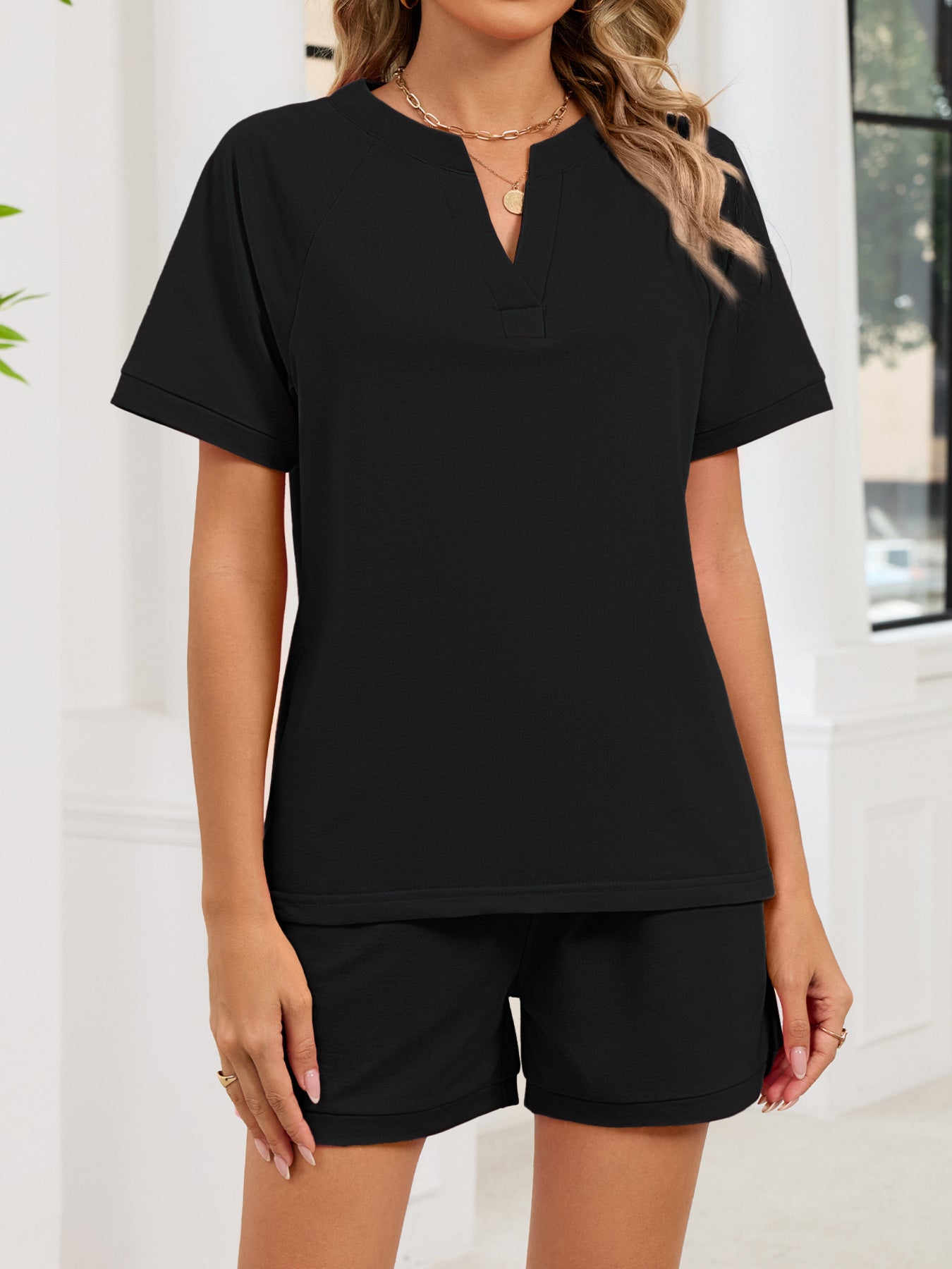 Black short sleeve loungewear top with V-neck and matching shorts.