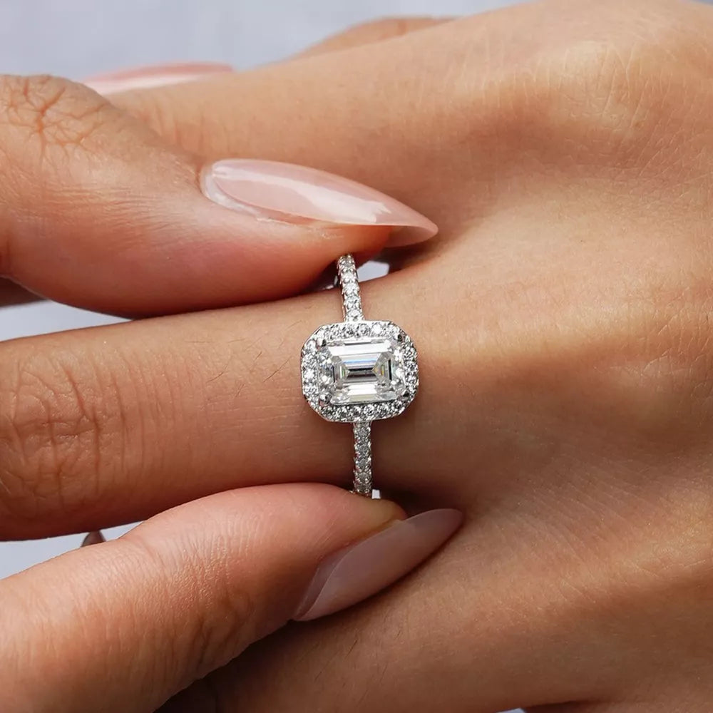 Radiant Moissanite engagement ring in silver with emerald cut center stone and diamond halo.