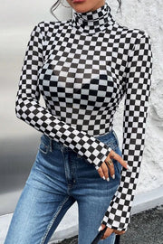Checkerboard mesh turtleneck bodysuit with long sleeves, styled with jeans.