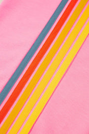 Pink track pants with rainbow stripe detail in blue, orange, and yellow.