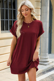 Burgundy cuffed sleeve pocket dress with crew neck and relaxed fit, shown on a woman.