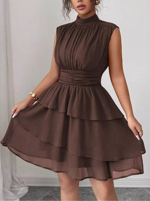 Brown sleeveless ruffle tiered dress with ruched waist and mock neck.