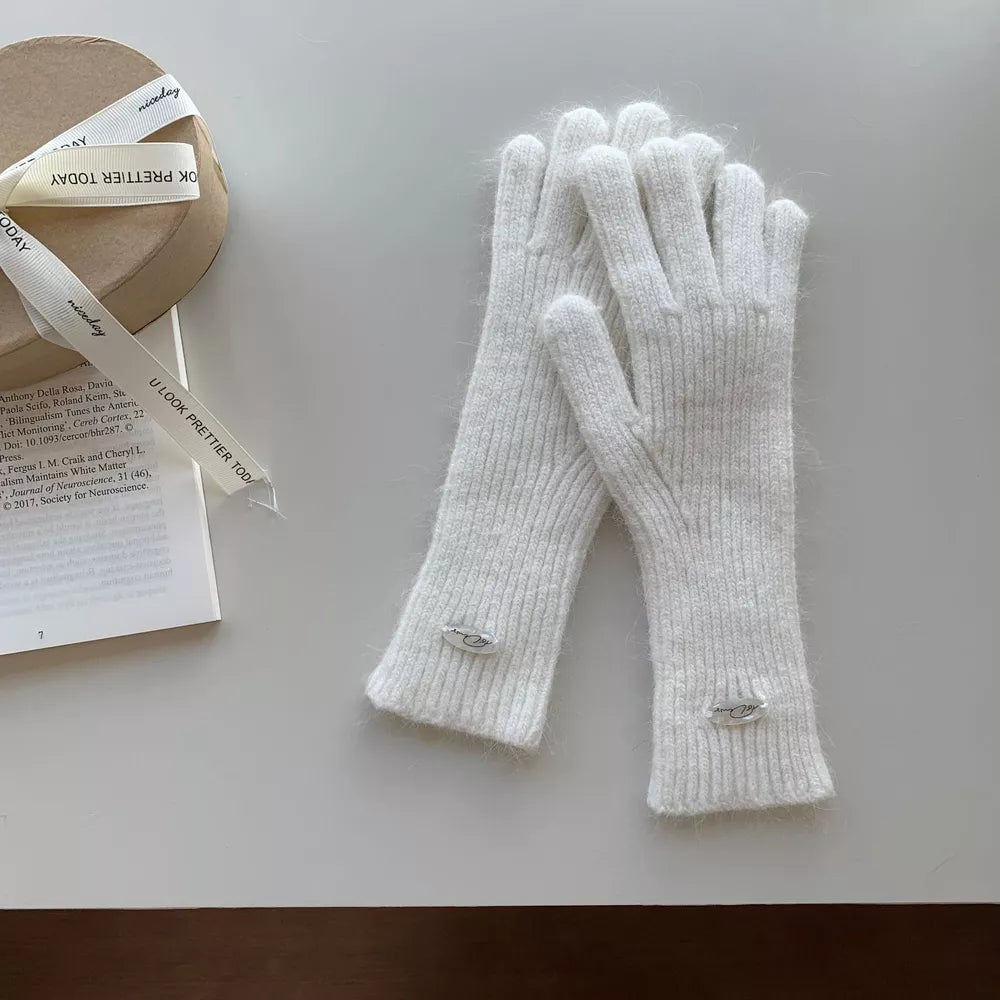 Ivory ribbed knit touchscreen gloves with fuzzy texture and silver logo detail.