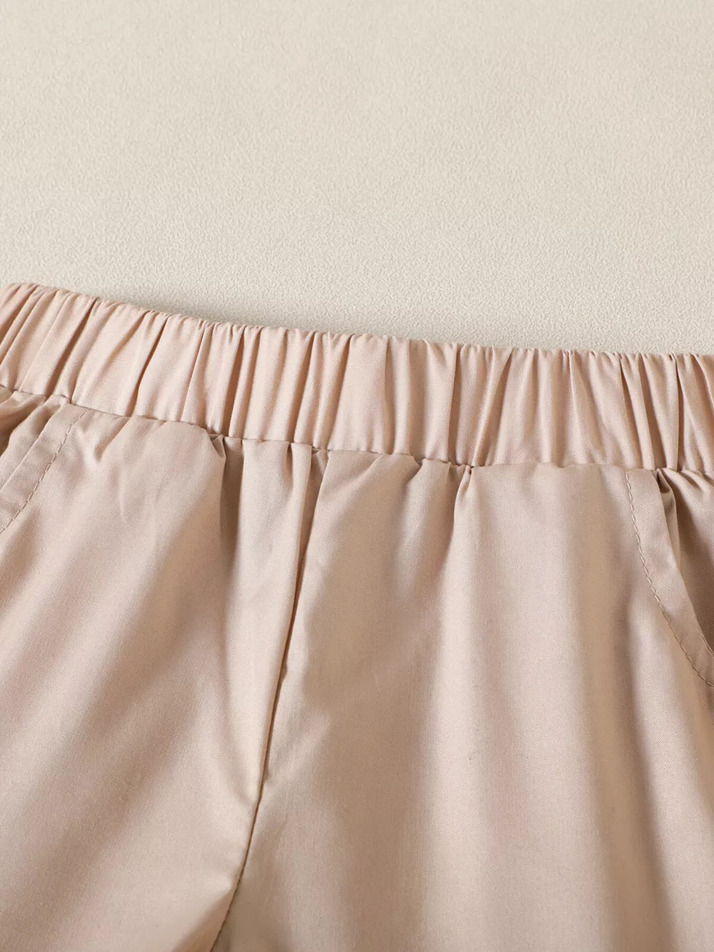 Baby cotton shorts with elastic waistband and pockets in tan.