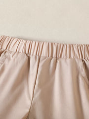 Baby cotton shorts with elastic waistband and pockets in tan.