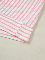 Pink and white striped seersucker blouse with textured fabric detail.
