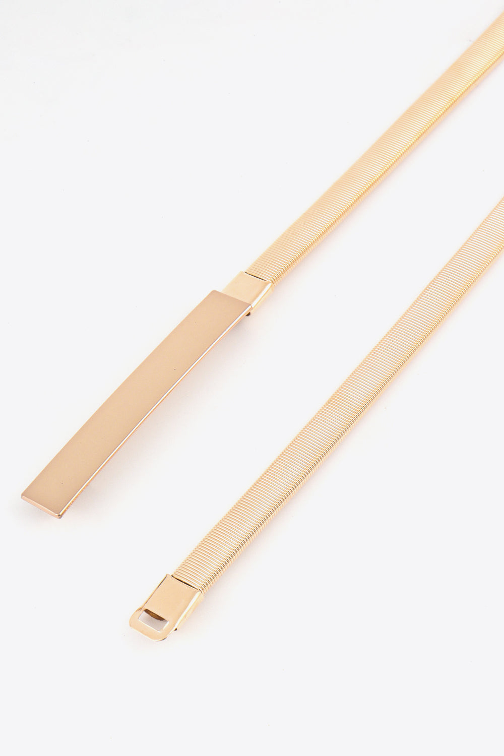 Gold-tone slimline metal belt with adjustable buckle and ribbed texture.