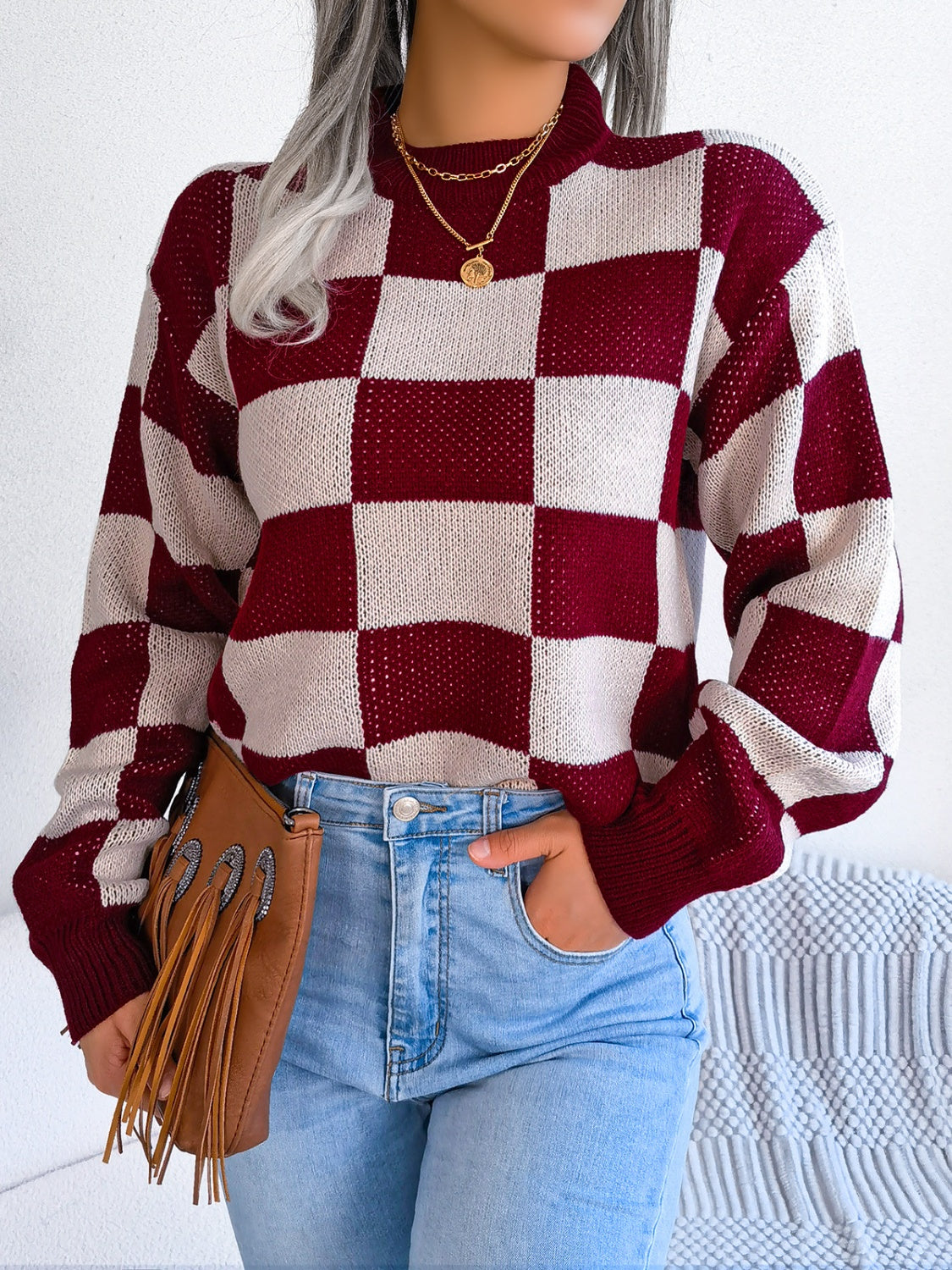 Checkerboard knit mock neck pullover sweater in burgundy and cream acrylic with long sleeves.