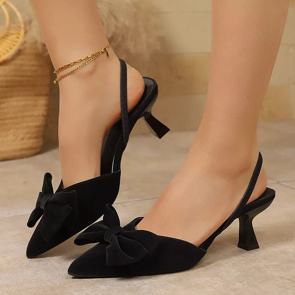 Black slingback kitten heels with bow detail and ankle strap.