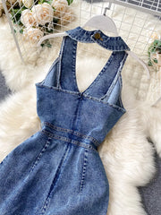Blue denim halter neck jumpsuit with button detail at collar and wide legs.