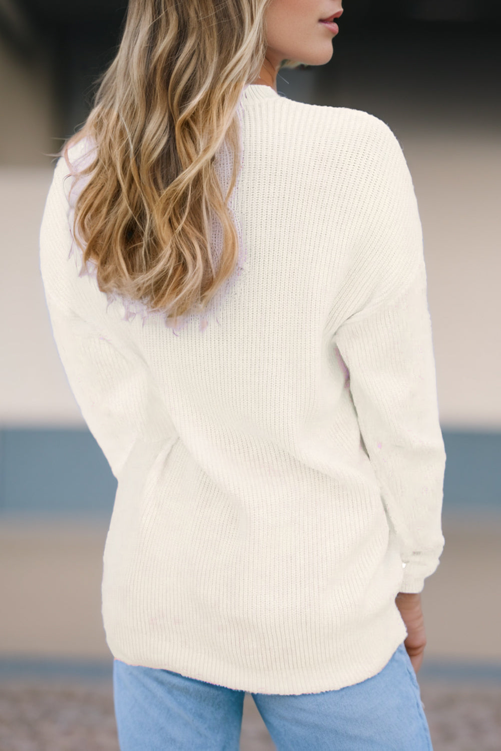 Ivory knit sweater with a textured stitch, crew neck, and relaxed fit.