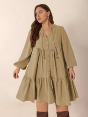 Olive green button-front tiered mini dress with tie-neck and balloon sleeves.