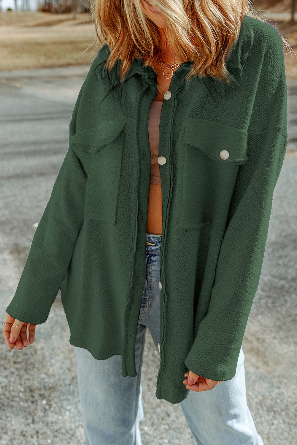 Dark green textured shacket with raw edge detailing and buttoned pockets.