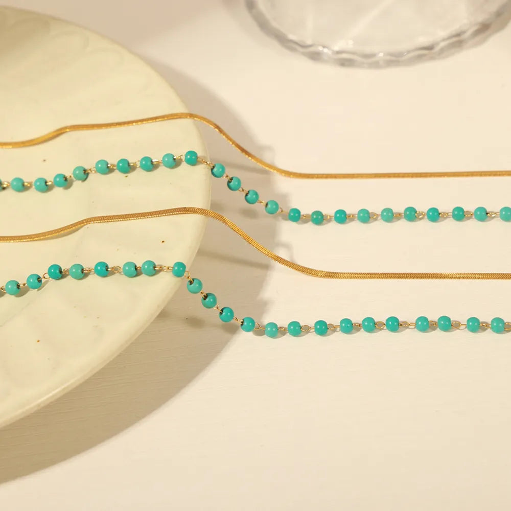 Gold layered necklace with turquoise beads and snake chain detail