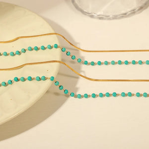 Gold layered necklace with turquoise beads and snake chain detail