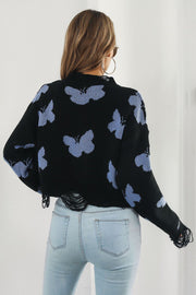 Black acrylic cropped sweater with butterfly intarsia pattern and frayed hem.