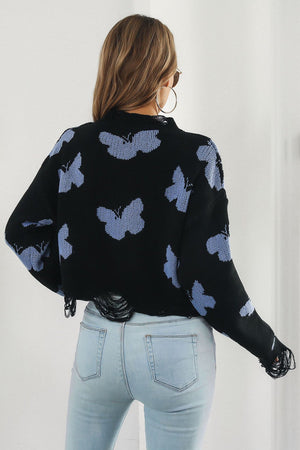 Black acrylic cropped sweater with butterfly intarsia pattern and frayed hem.