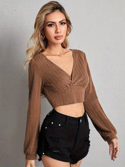 Textured wrap-front crop top in tan with long sleeves and a V-neck.